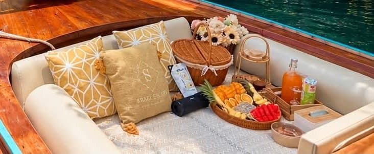 Fresh fruit, juice and a picnic basket laid out on board